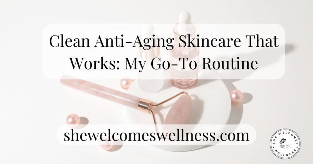 A flat lay of skincare products: a rose quartz roller, serums on a white plate, and pink pearls. Text overlay: "Clean Anti-Aging Skincare." Logo reads "shewelcomeswellness.com."
