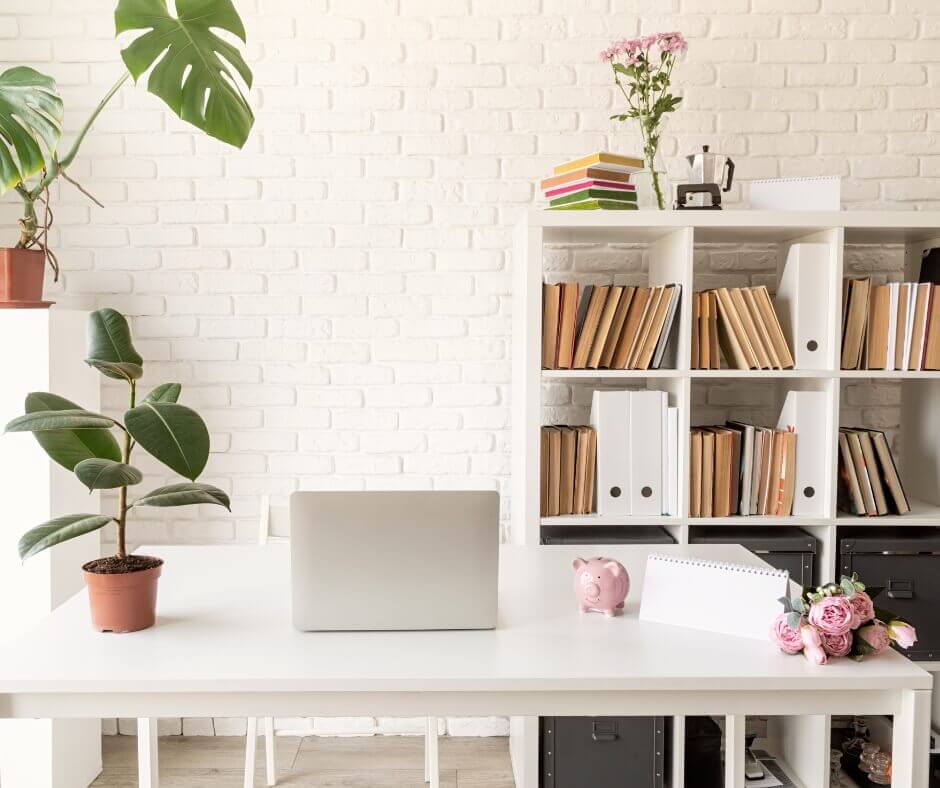 white office space with desk, plants, resources and resource books